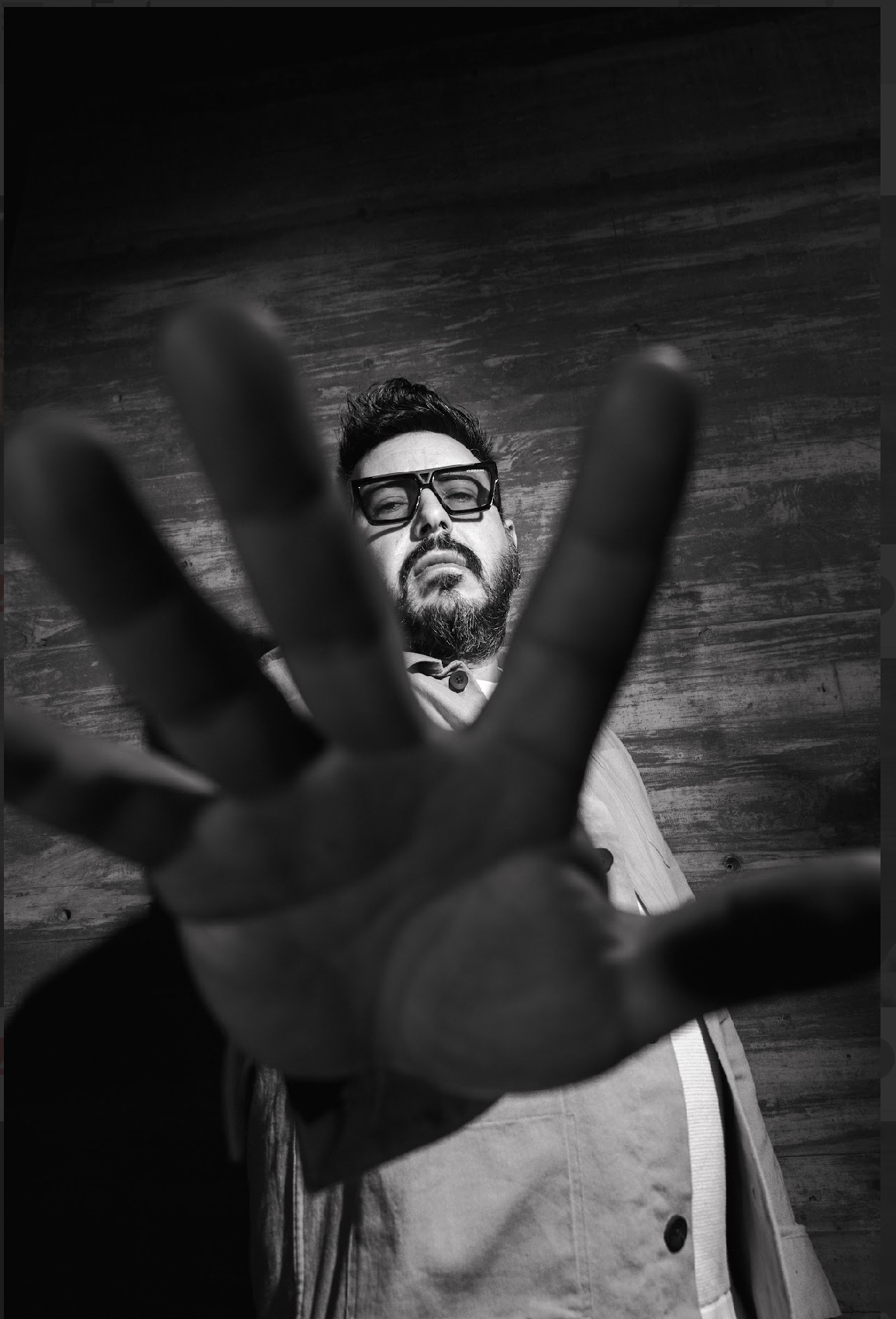 Black and white portrait of Frankie Mares reaching toward the camera
